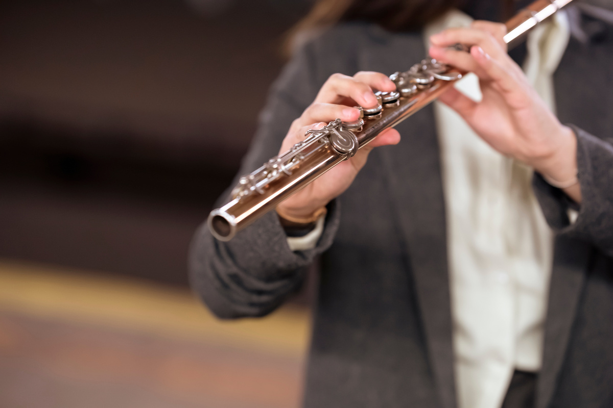 Woman in elegant suit playing flute